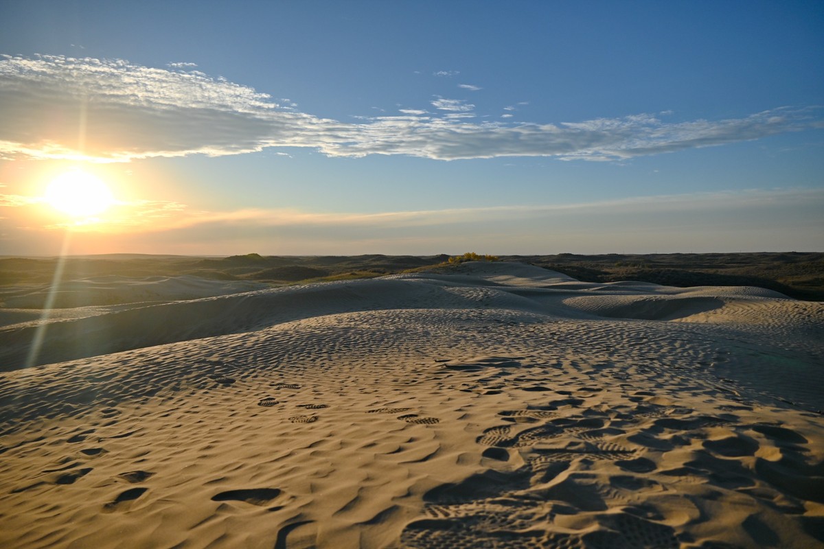 Sun setting over rippled sand dunes at the Great Sand Hills in Saskatchewan.