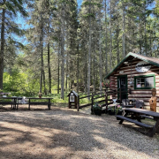 Log cabin-style Treats and Treasures store at Madge Lake, surrounded by trees and picnic tables.