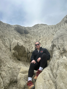Ella sitting among the pale rock formations at Castle Butte in the Big Muddy Badlands of southern Saskatchewan under a cloudy sky.