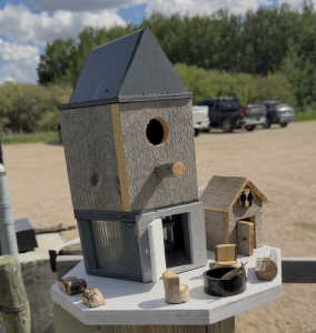FancyBirdHouse Decorative multi-level birdhouse with miniature buildings, furniture, and details displayed near the White Butte trailhead.
